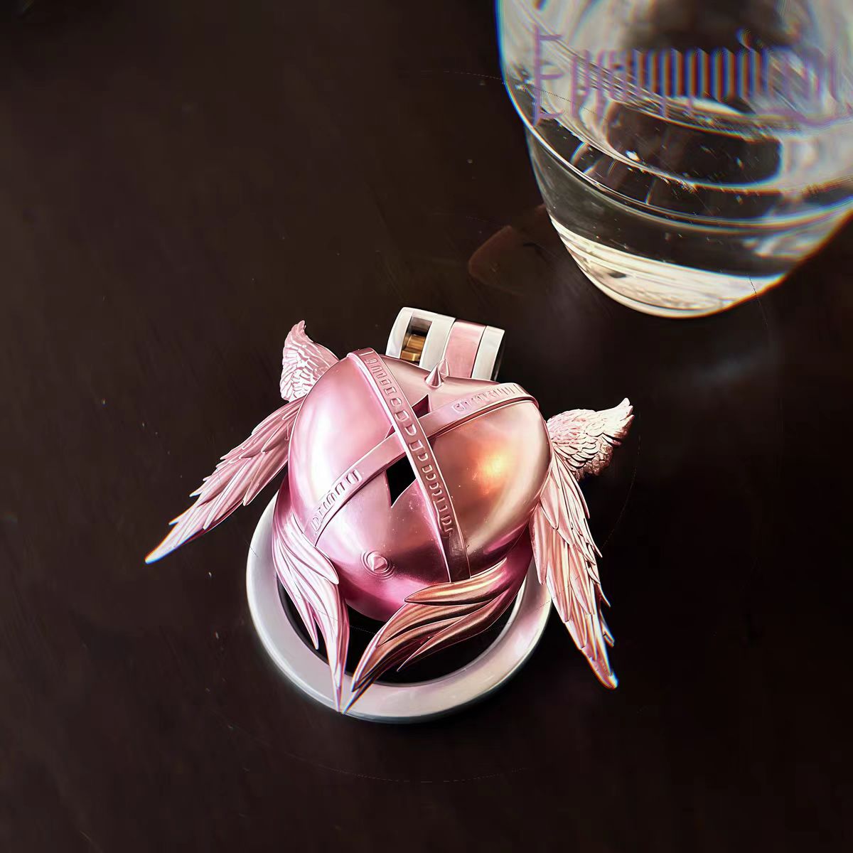 Pinker Käfig neben einem Glas
